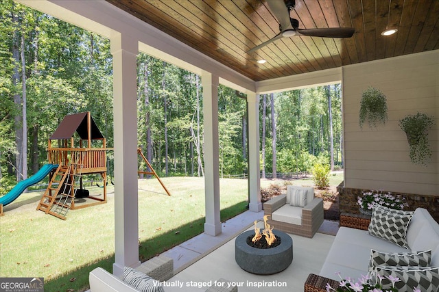 view of patio / terrace with ceiling fan, a playground, and an outdoor living space with a fire pit