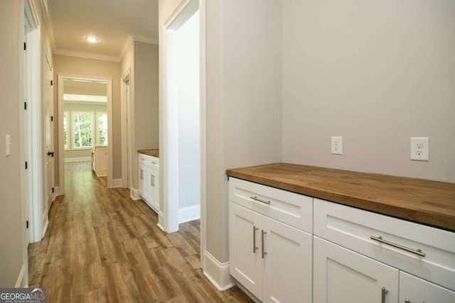 hall featuring ornamental molding and light hardwood / wood-style flooring