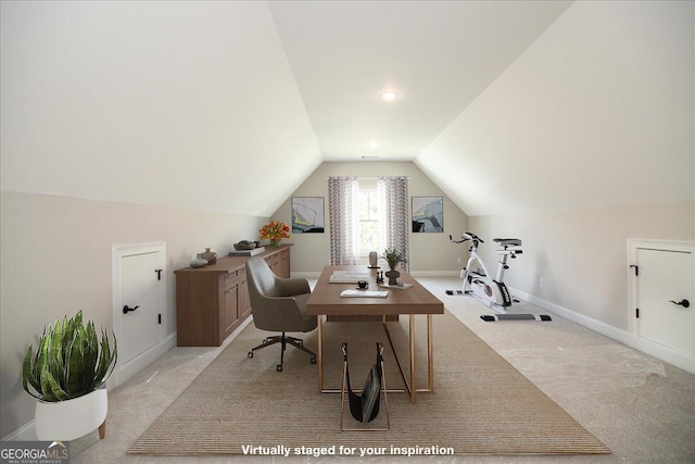 office area with light colored carpet and vaulted ceiling