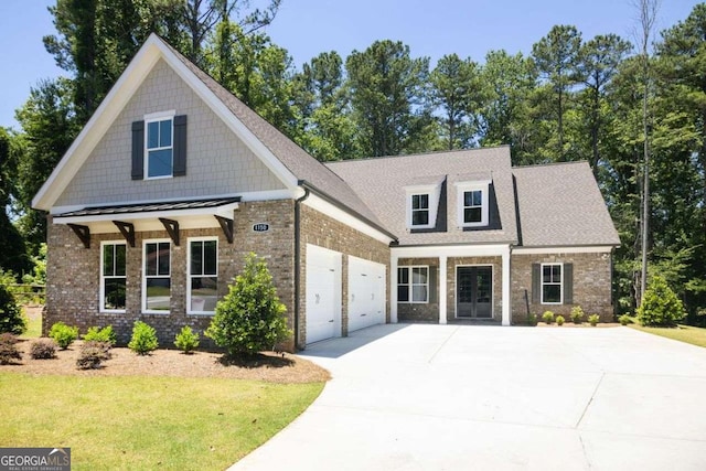 view of front of home with covered porch, a garage, and a front lawn