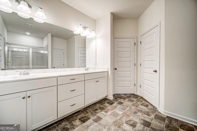 bathroom with vanity and a shower with door