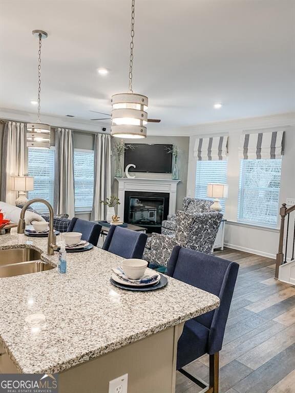 kitchen with a healthy amount of sunlight, sink, a breakfast bar area, and a kitchen island with sink