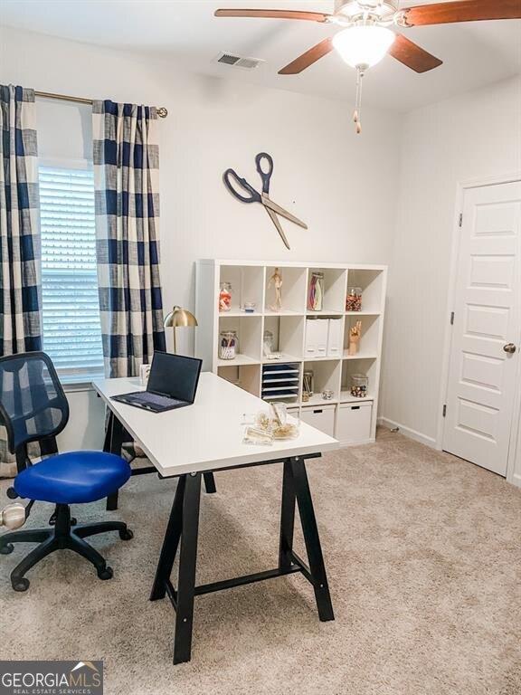 carpeted office featuring ceiling fan