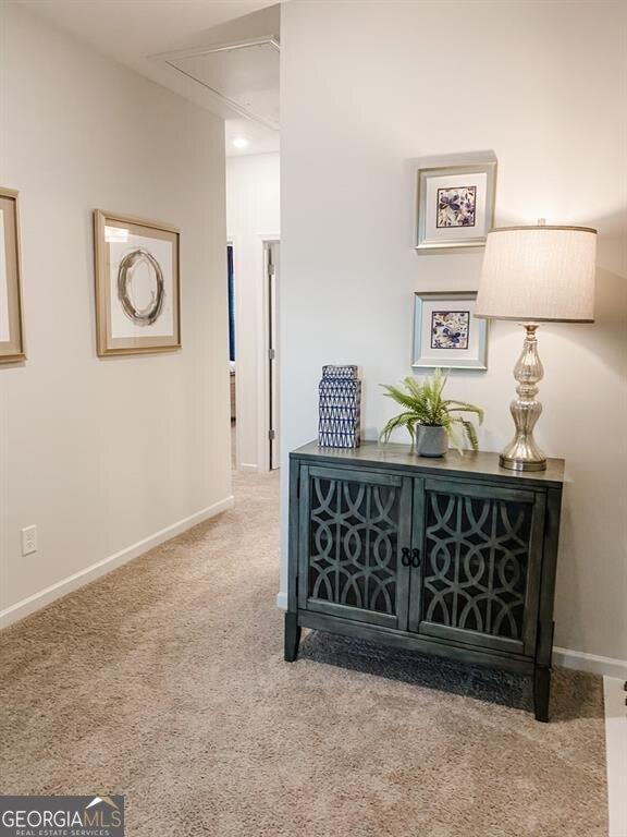 hall featuring light colored carpet