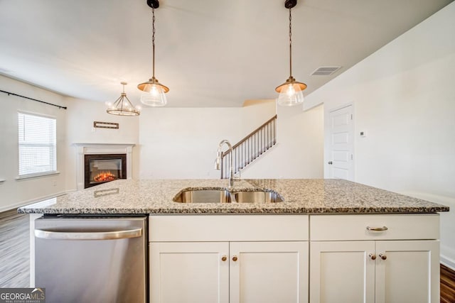 kitchen featuring light stone countertops, dishwasher, sink, dark hardwood / wood-style floors, and white cabinets