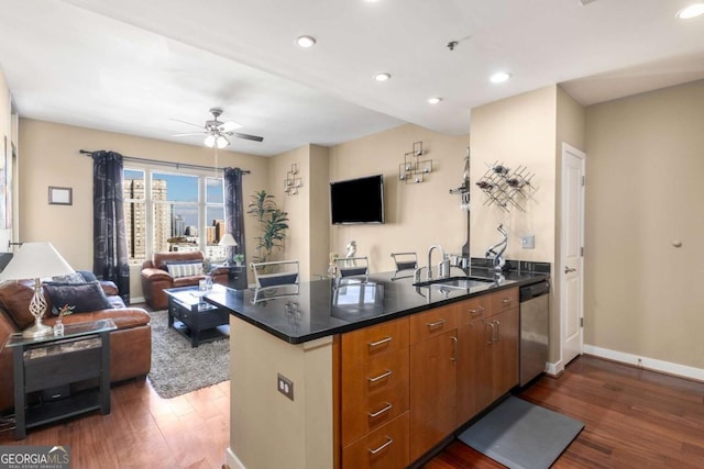 kitchen featuring kitchen peninsula, ceiling fan, sink, dishwasher, and dark hardwood / wood-style floors