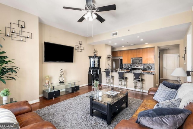 living room with ceiling fan and dark hardwood / wood-style flooring