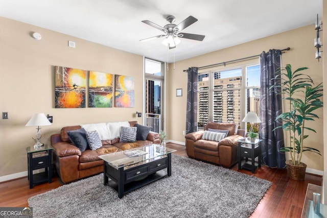 living room with ceiling fan and dark wood-type flooring