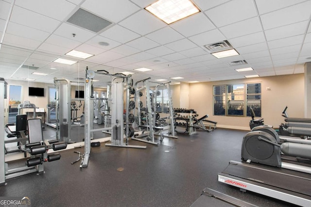 gym featuring a drop ceiling and a wealth of natural light