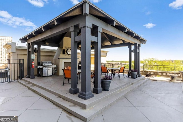 view of patio / terrace with a gazebo, area for grilling, and an outdoor fireplace