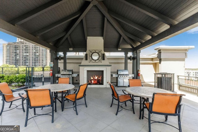 view of patio / terrace featuring a gazebo, grilling area, and a tiled fireplace