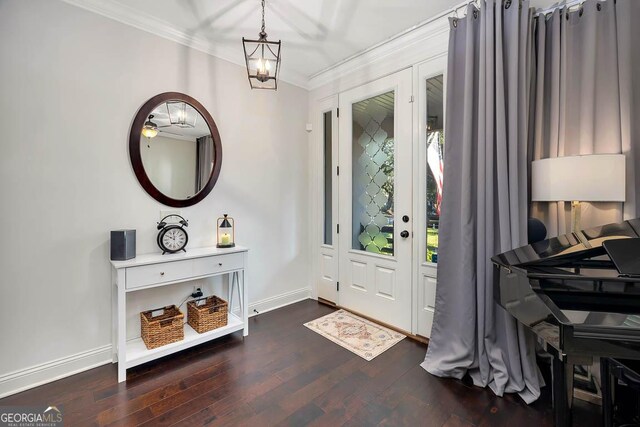 entrance foyer with dark hardwood / wood-style floors, an inviting chandelier, and crown molding