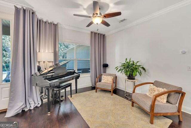 living area featuring hardwood / wood-style flooring, ceiling fan, and crown molding