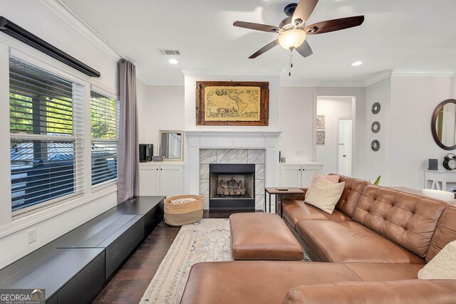 living room featuring a tile fireplace, ceiling fan, dark hardwood / wood-style floors, and ornamental molding