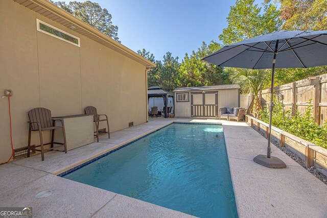 view of pool with a gazebo, a patio, and a storage shed