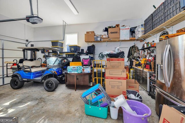 garage featuring stainless steel fridge and a garage door opener