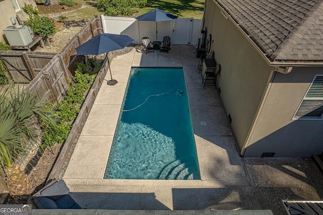 view of pool with a patio area and central air condition unit