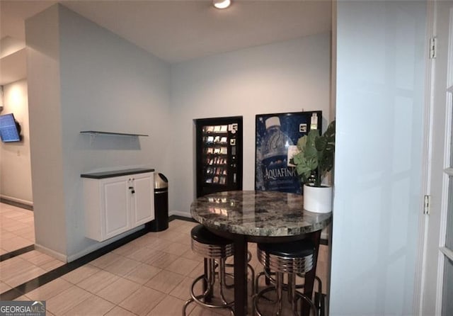 bar featuring white cabinets and light tile patterned flooring