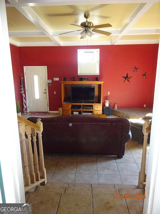 tiled living room with ceiling fan and coffered ceiling