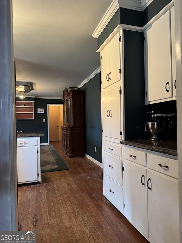 kitchen featuring white cabinets, dark hardwood / wood-style flooring, and ornamental molding