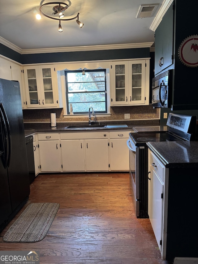 kitchen featuring black appliances, white cabinets, sink, and hardwood / wood-style flooring