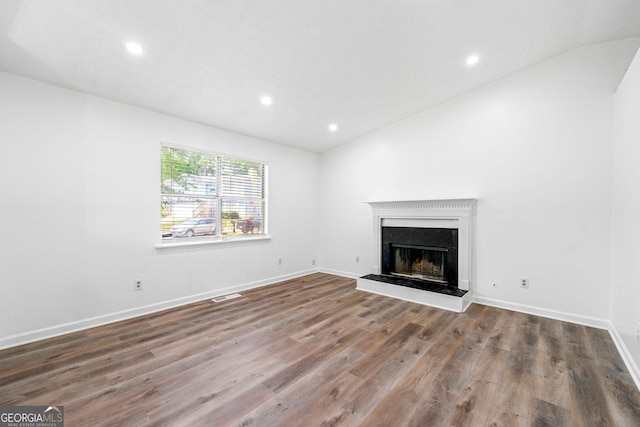 unfurnished living room featuring hardwood / wood-style floors and vaulted ceiling