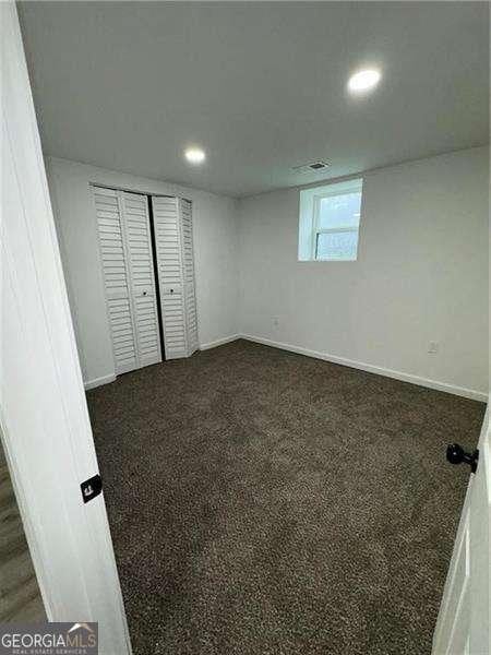 basement featuring dark carpet