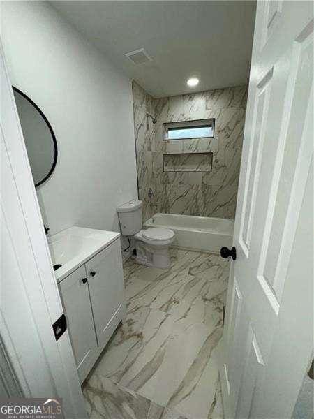 full bathroom with vanity, toilet, and tiled shower / bath