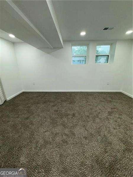 basement featuring dark carpet