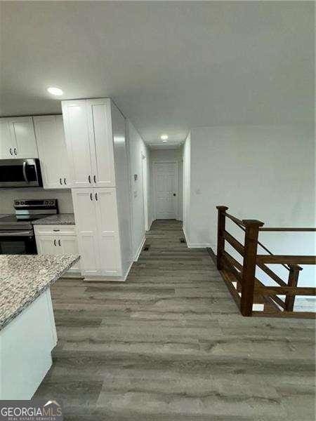 hallway with hardwood / wood-style flooring