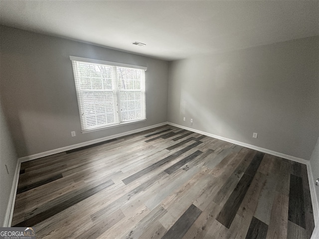 spare room featuring wood-type flooring