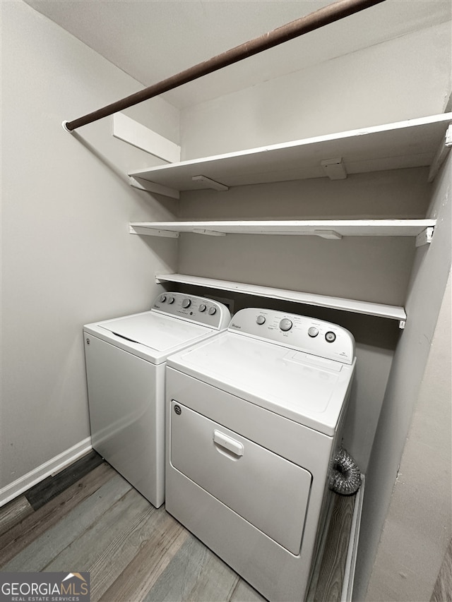 clothes washing area featuring washer and dryer and wood-type flooring