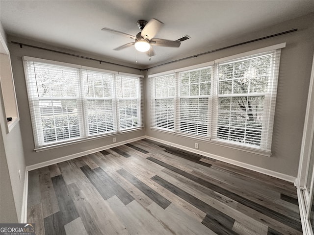 unfurnished sunroom featuring ceiling fan