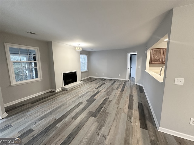 unfurnished living room featuring a wealth of natural light and hardwood / wood-style flooring