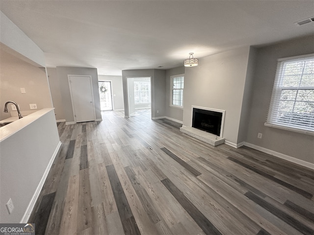 unfurnished living room featuring dark hardwood / wood-style floors and a healthy amount of sunlight