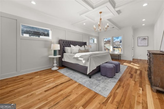 bedroom with coffered ceiling, beam ceiling, light hardwood / wood-style flooring, and a chandelier