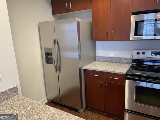 kitchen with stainless steel appliances and dark hardwood / wood-style floors