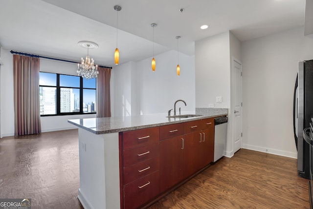 kitchen featuring dark hardwood / wood-style floors, sink, light stone counters, kitchen peninsula, and stainless steel appliances