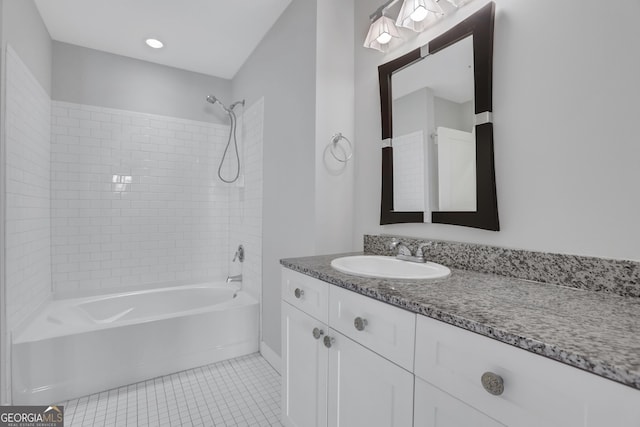 bathroom with tile patterned flooring, vanity, and tiled shower / bath