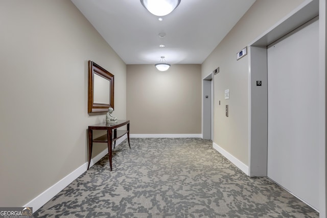 hallway featuring carpet flooring and elevator