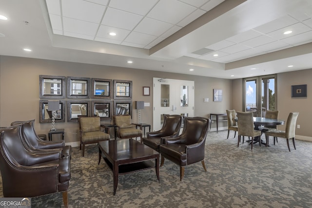 living room featuring a drop ceiling, a tray ceiling, french doors, and dark colored carpet