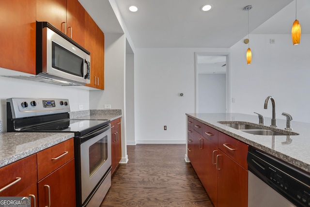 kitchen featuring dark wood-type flooring, sink, decorative light fixtures, stainless steel appliances, and light stone countertops