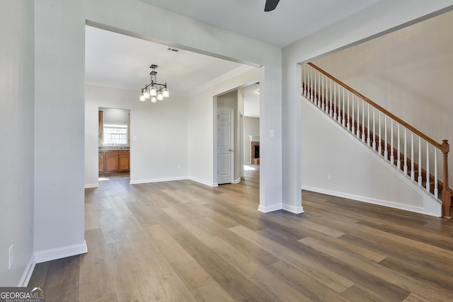 interior space with sink, light hardwood / wood-style floors, ornamental molding, and a notable chandelier