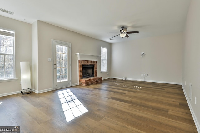 unfurnished living room featuring a brick fireplace, ceiling fan, and hardwood / wood-style flooring