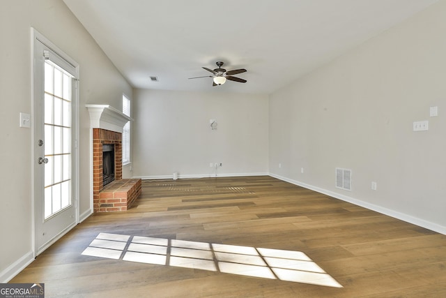 unfurnished living room with a fireplace, ceiling fan, and hardwood / wood-style floors