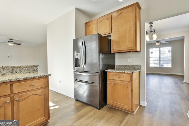 kitchen with light hardwood / wood-style flooring, ceiling fan, stainless steel fridge, light stone countertops, and ornamental molding