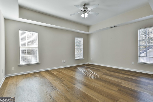 unfurnished room with plenty of natural light, ceiling fan, and dark wood-type flooring