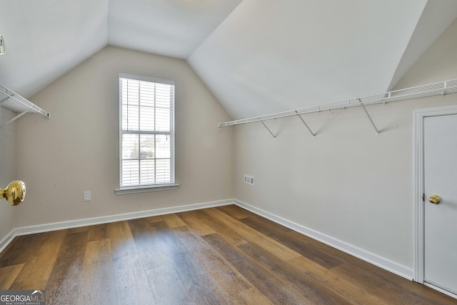 spacious closet featuring dark hardwood / wood-style flooring and vaulted ceiling