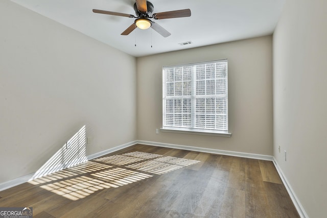 unfurnished room with ceiling fan and dark wood-type flooring