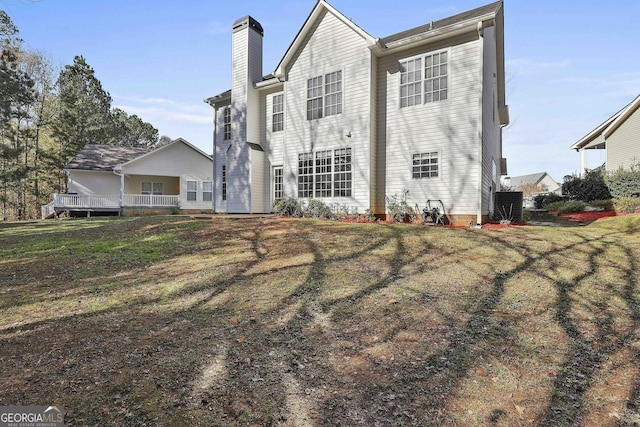 rear view of house featuring a yard